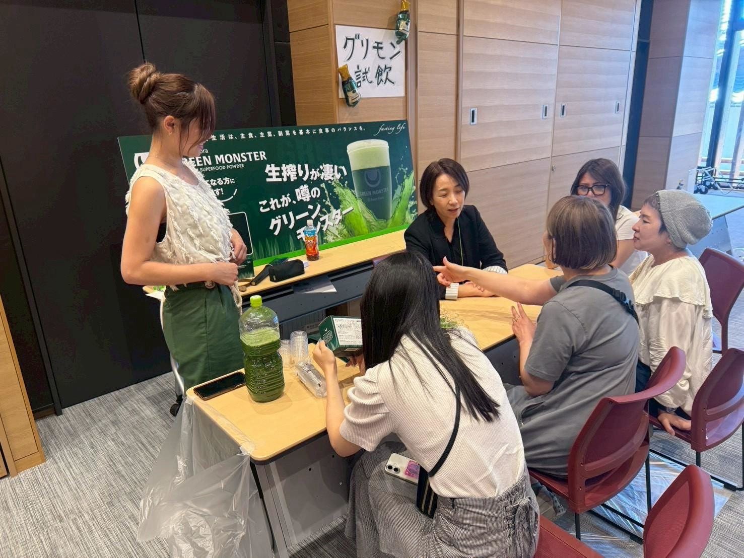 グリーンモンスター試飲ブースで参加者に説明する様子